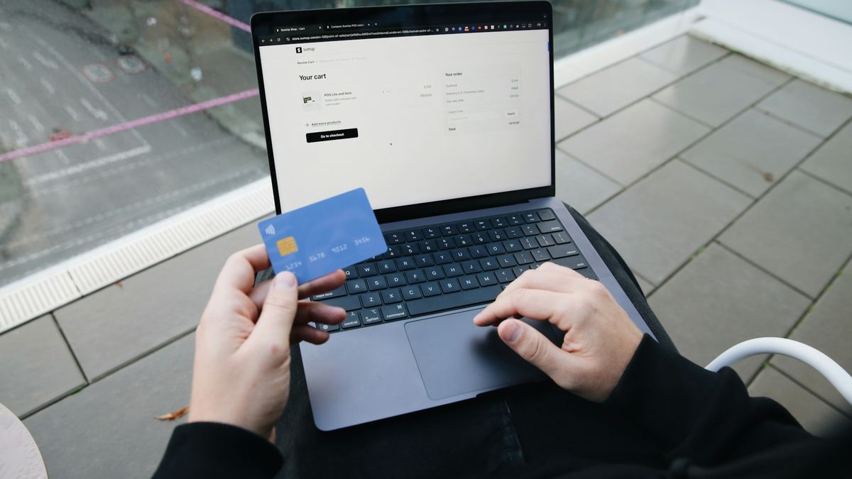 Shopper paying online with a card on a laptop
