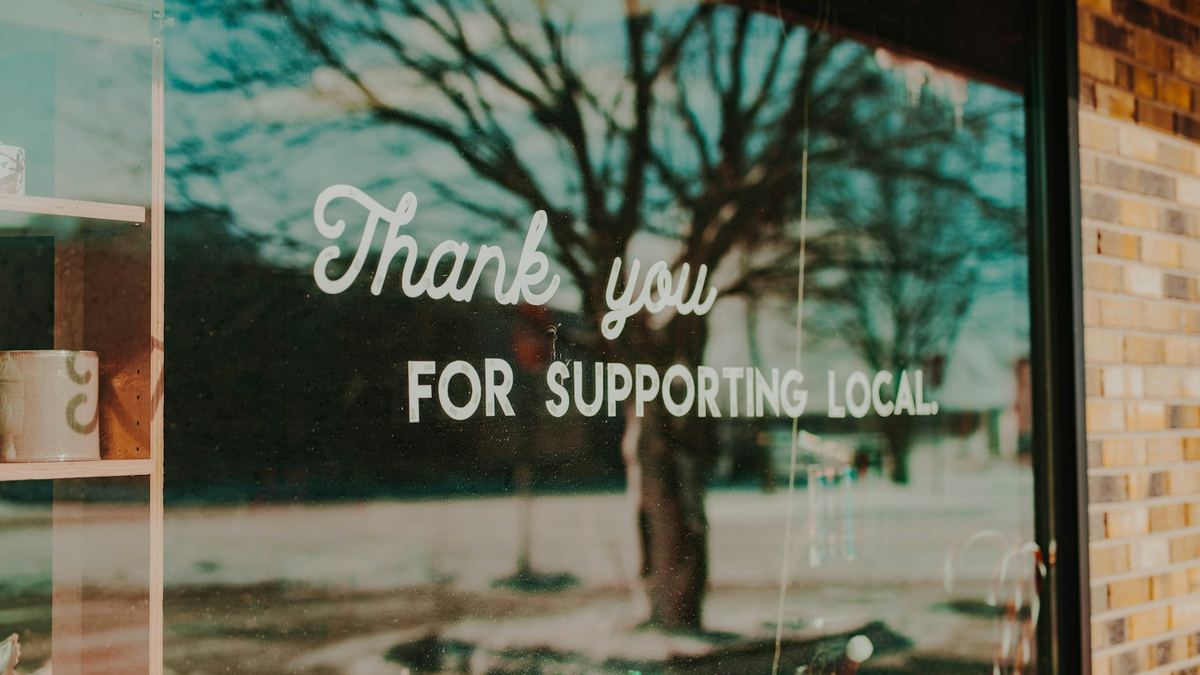 Shop window sign saying thank you for supporting local