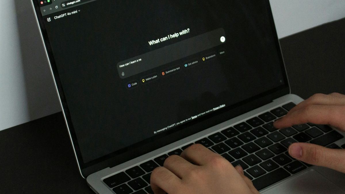 Person typing a prompt into an AI chat on a laptop